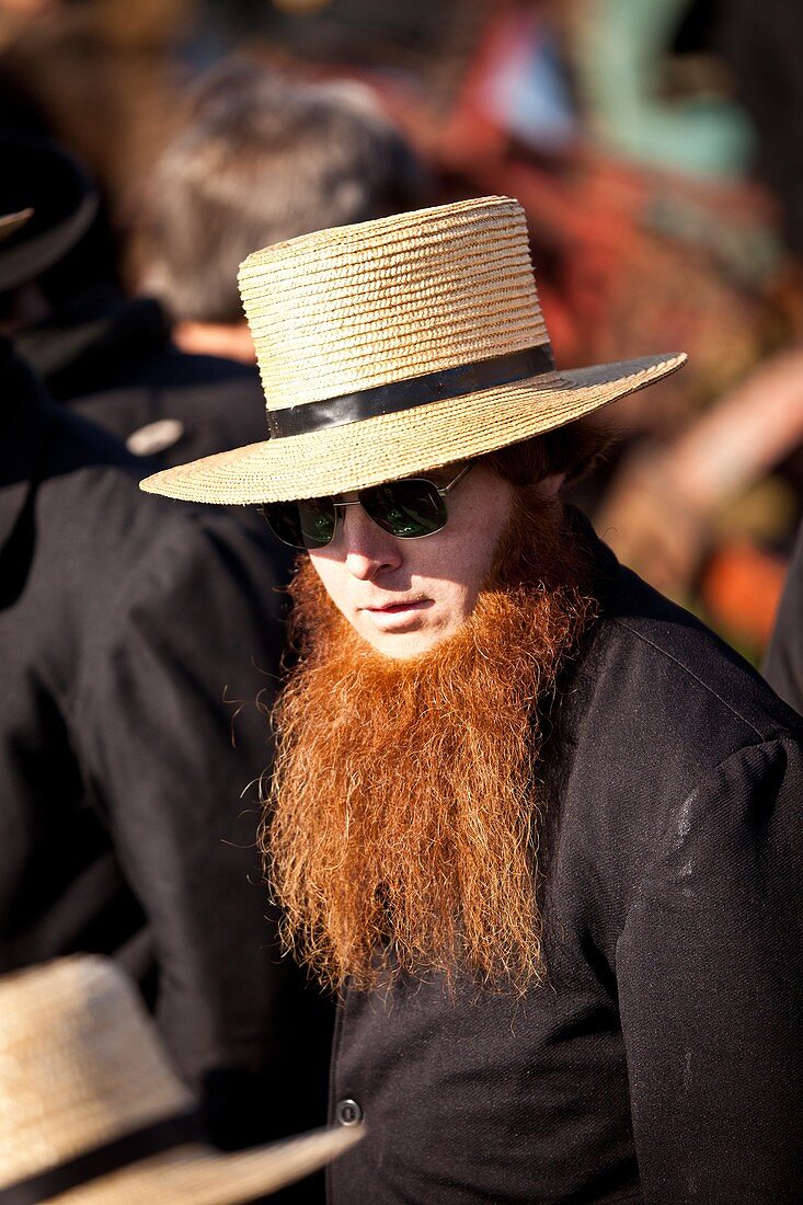 Amish man with a red beard bids on farm equipment during the Annual Mud Sale to support the Fire Department in Gordonville, PA