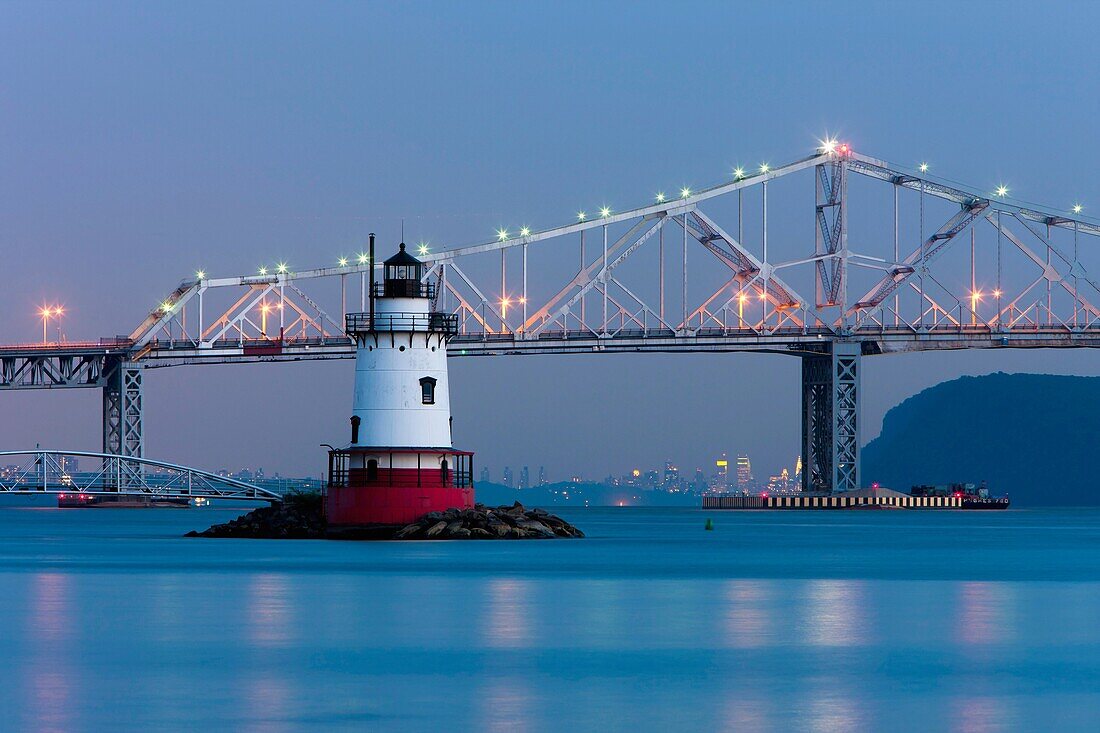 Twilight view of the Tarrytown Lighthouse and Tappan Zee Bridge on the Hudson River near the village of Sleepy Hollow, New York, with the skyline of Manhattan in New York City approximately 25 miles away in the background.