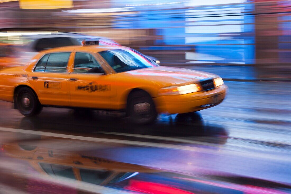 Motion blurred abstraction of taxi rushing through Times Square in New York City, New York, USA