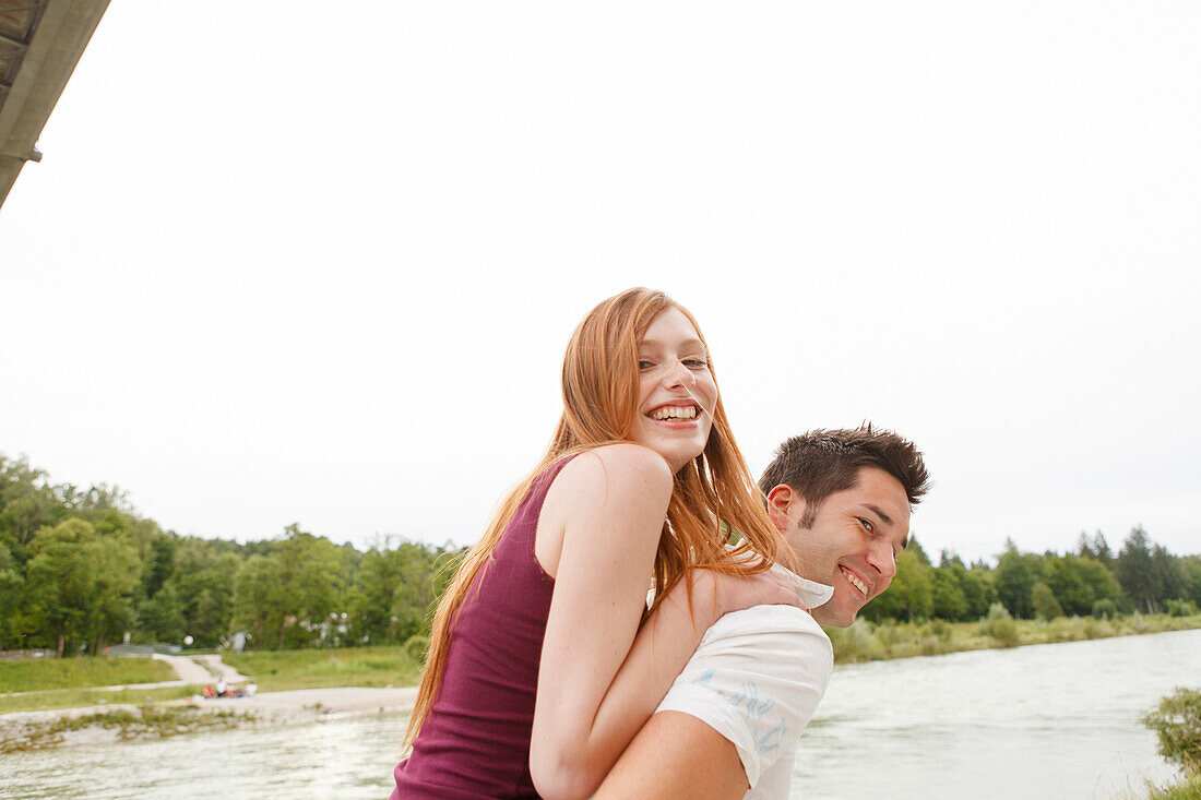 Young couple on bank of Isar river, Munich, Bavaria, Germany