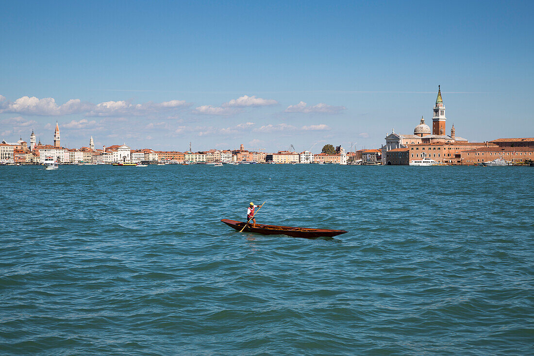Gondoliere rowing gondola across the Canale della Guidecca, Venice, Veneto, Italy, Europe