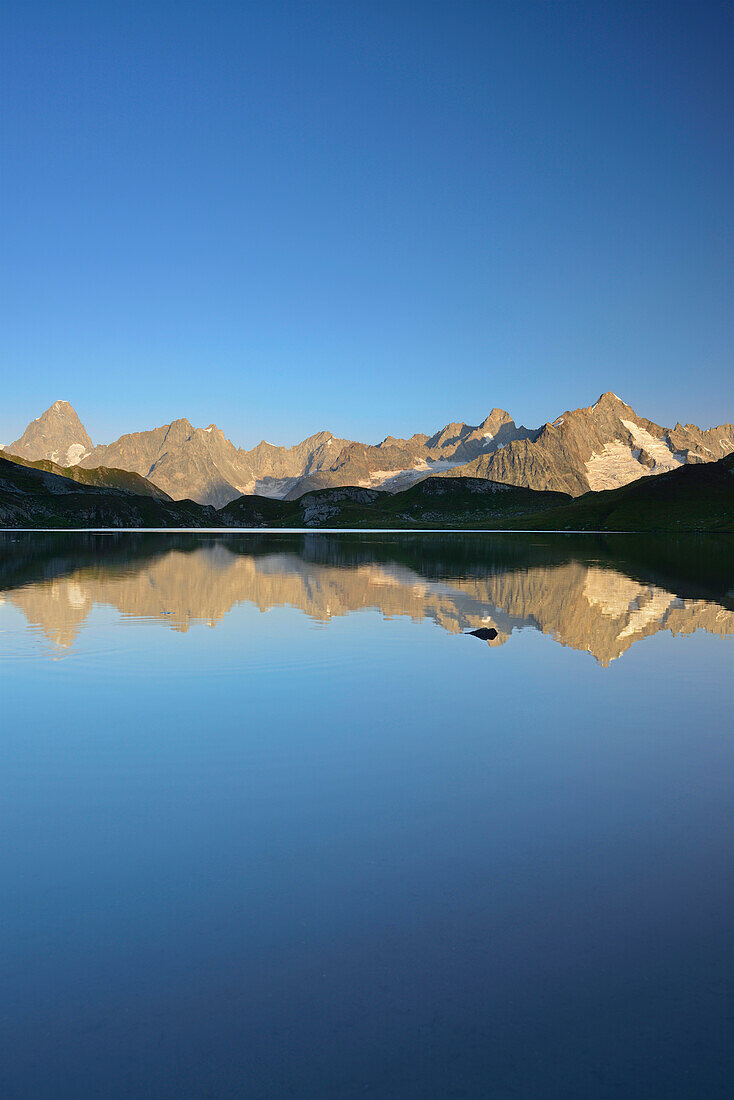 Mont Blanc range with Grandes Jorasses and Mont Dolent reflecting in a mountain lake, Pennine Alps, Aosta valley, Italy