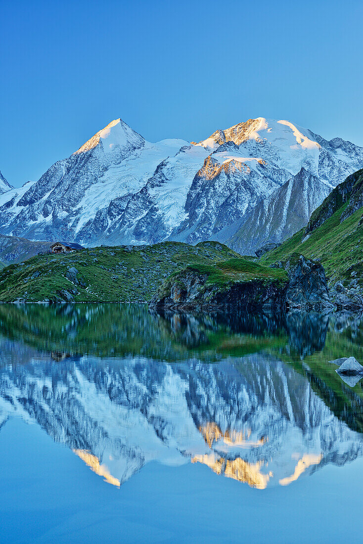 Combin de Corbassiere and Petit Combin reflecting in a mountain lake, Pennine Alps, Valais, Switzerland
