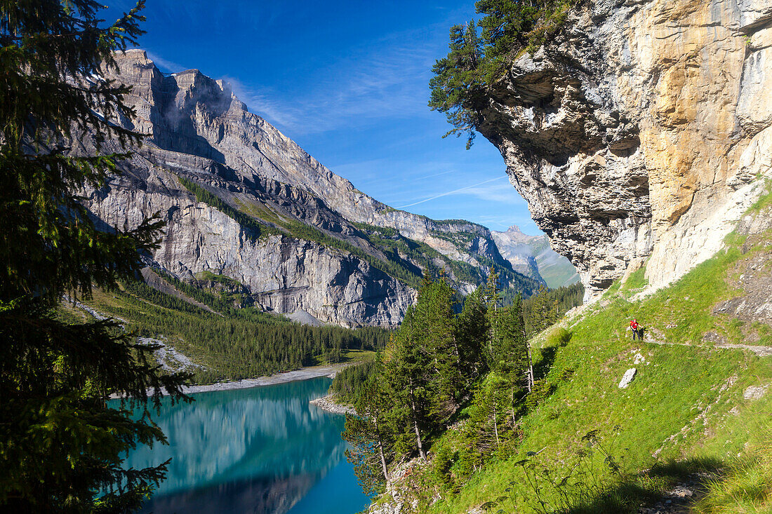 A man hiking at lake Oeschinen, Bernese Oberland, Canton of Bern, Switzerland