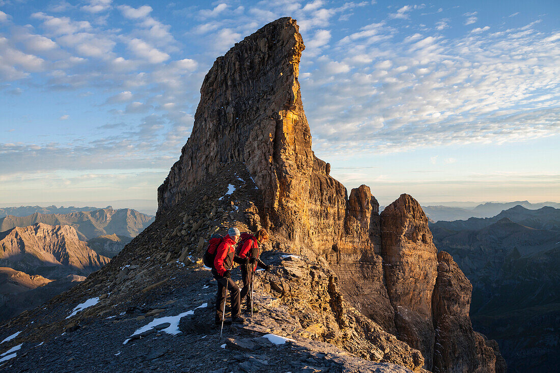 A man and a woman hiking on the summit of Mount Wildi Frau, Bernese Oberland, Canton of Bern, Switzerland