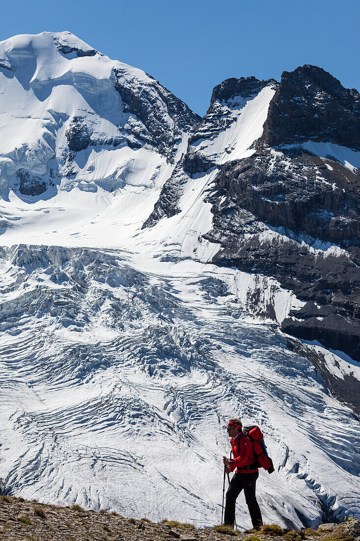 A man hiking, mountaineering in front of Bluemlisalp mountains, Kander Valley, view from the ridge between Schwarzhorn and Bundstock, Bernese Oberland, Canton of Bern, Switzerland
