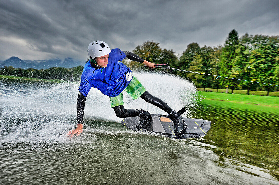 Junger Mann surft auf Wakeboard, Wakeboarding, Neubeurer See, Neubeuern, Rosenheim, Oberbayern, Bayern, Deutschland