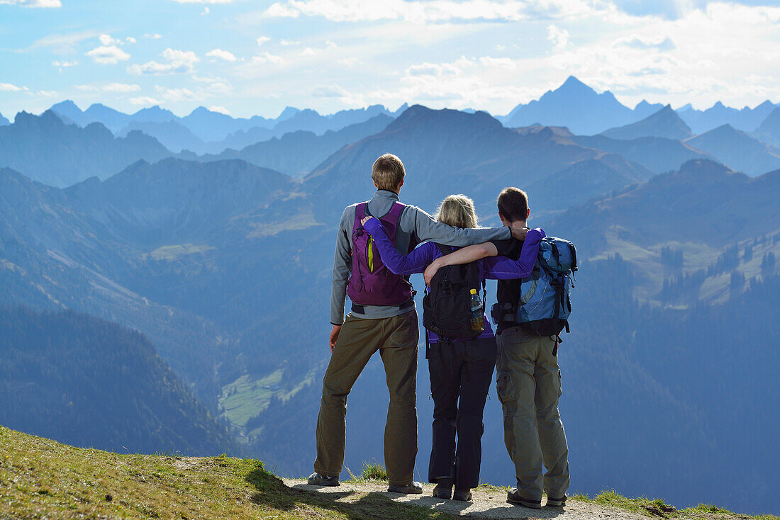 Young woman and two young men enjoying the view from Aggenstein Allgaeu range, Aggenstein, Tannheim range, Tyrol, Austria