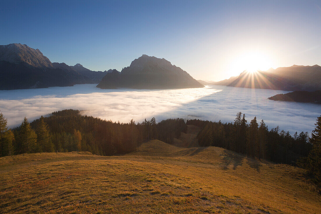 Blick über den Nebel im Tal auf Watzmann, Hochkalter und Reiteralpe bei Sonnenaufgang, Berchtesgadener Land, Nationalpark Berchtesgaden, Oberbayern, Bayern, Deutschland, Europa