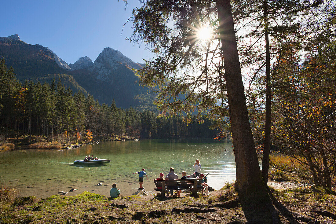 Family sitting on a bench at the shore of lake Hintersee, Ramsau, Berchtesgaden region, Berchtesgaden National Park, Upper Bavaria, Germany, Europe