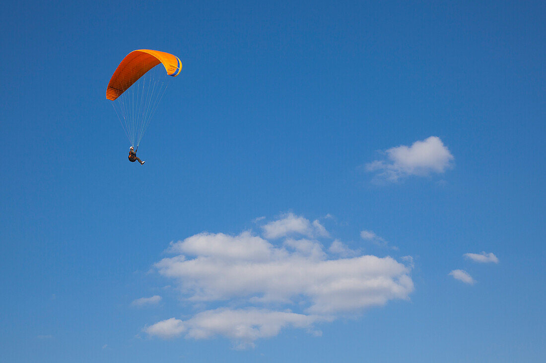 Paraglider in front of clouded sky