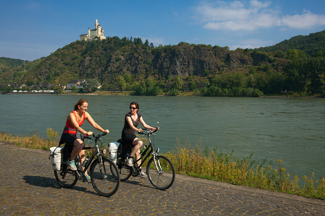 Zwei Radfahrerinnen vor der Marksburg, Unesco Weltkulturerbe, bei Braubach, Rhein, Rheinland-Pfalz, Deutschland