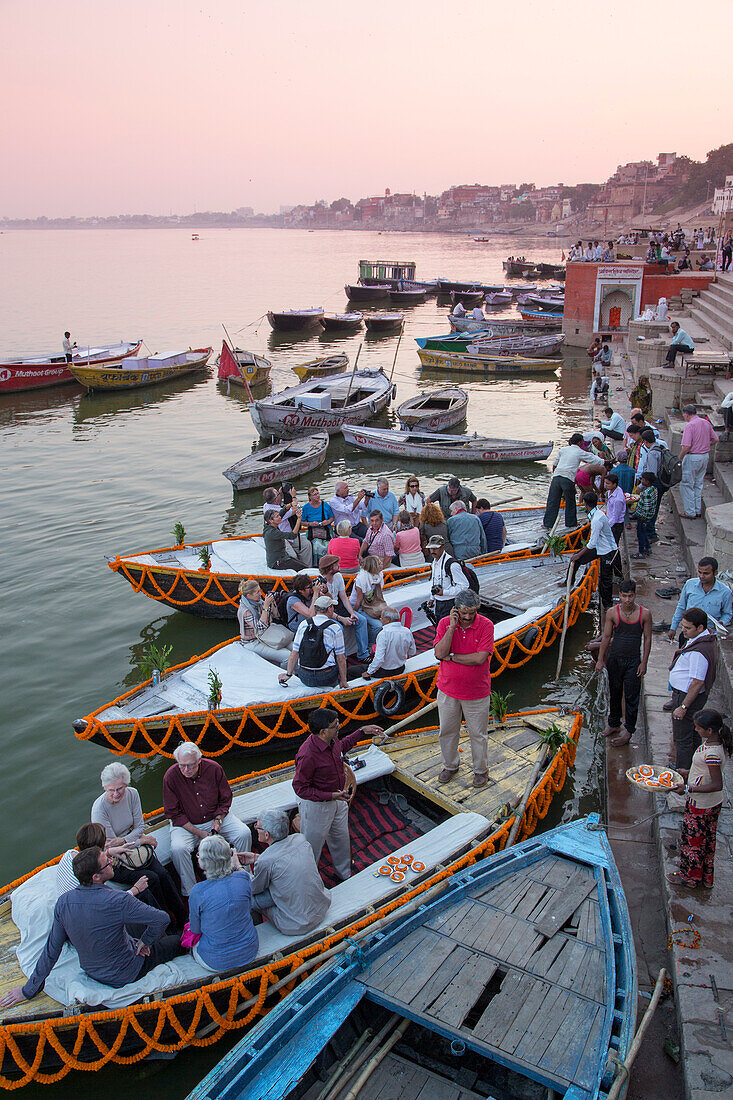 Touristen steigen in Ausflugsboot am Dasaswamedh Ghat am Ufer des Fluss Ganges, Varanasi, Uttar Pradesh, Indien