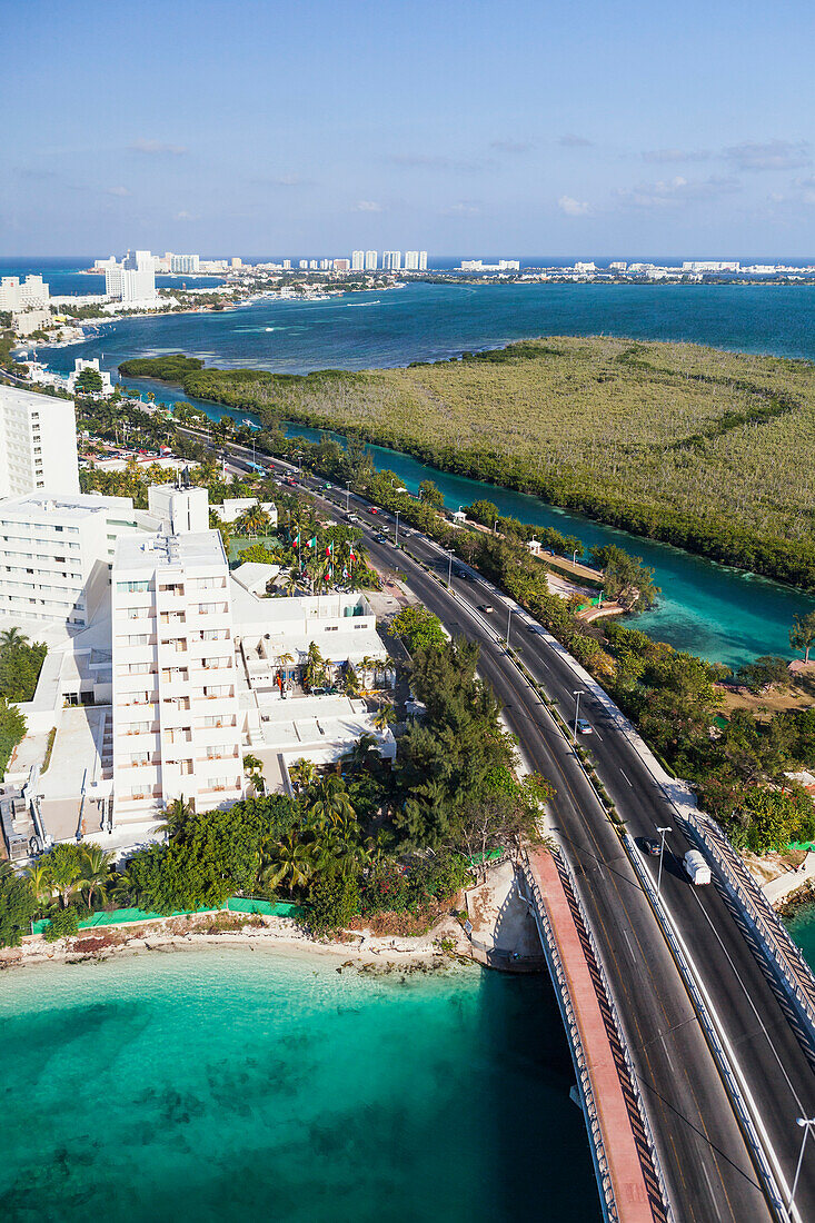 Aerial view over the hotel zone at Cancun. A major highway, road, hotels and resort buildings, along the coast.