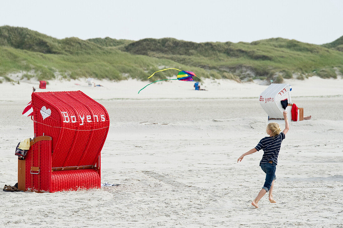 Colorful beach chairs and playing girl, sandbank near Norddorf, Amrum, North Frisian Islands, Schleswig-Holstein, Germany