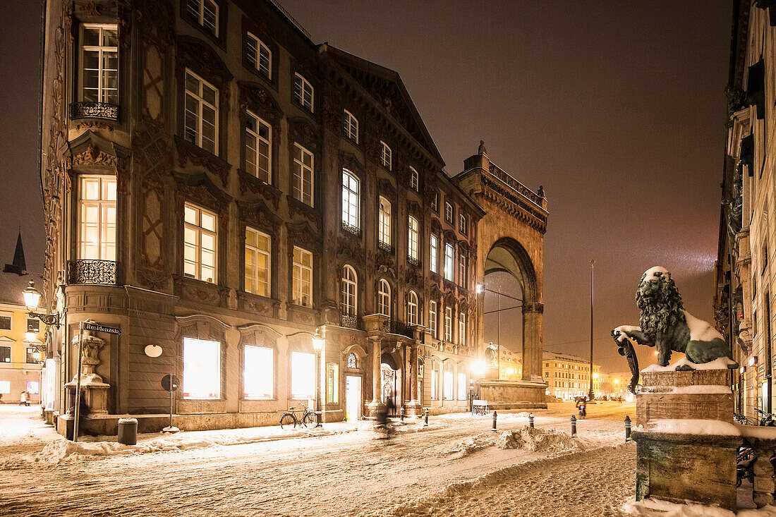 Feldherrnhalle, Odeonsplatz and lion statue, bicyclist at night in snow drift, Munich, Upper Bavaria, Bavaria, Germany