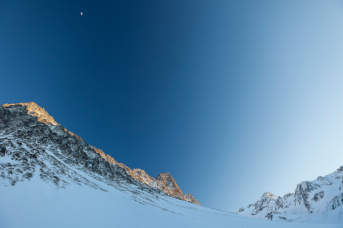 Lisenser Fernerkogl, Brunnenkogl and Bachfallenkopf in winter with half moon at sunset, view from Laengental valley, Sellrain, Innsbruck, Tyrol, Austria