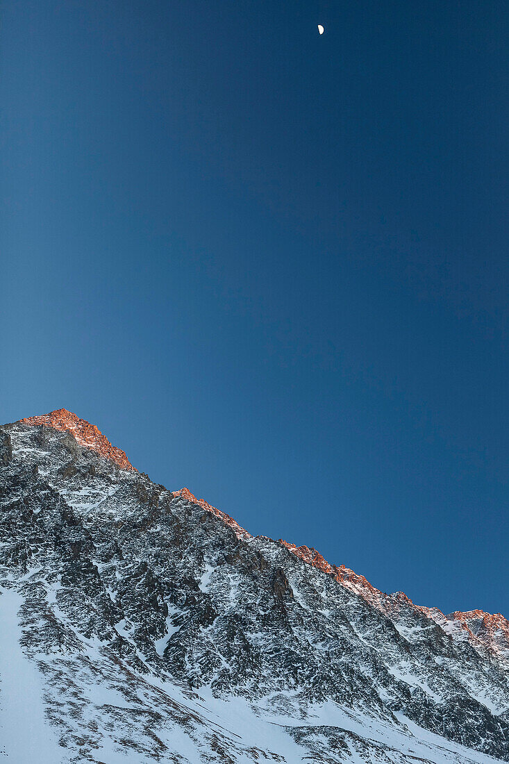 Lisenser Fernerkogl in winter at sunset with half moon, view from Längental valley, Sellrain, Innsbruck, Tyrol, Austria