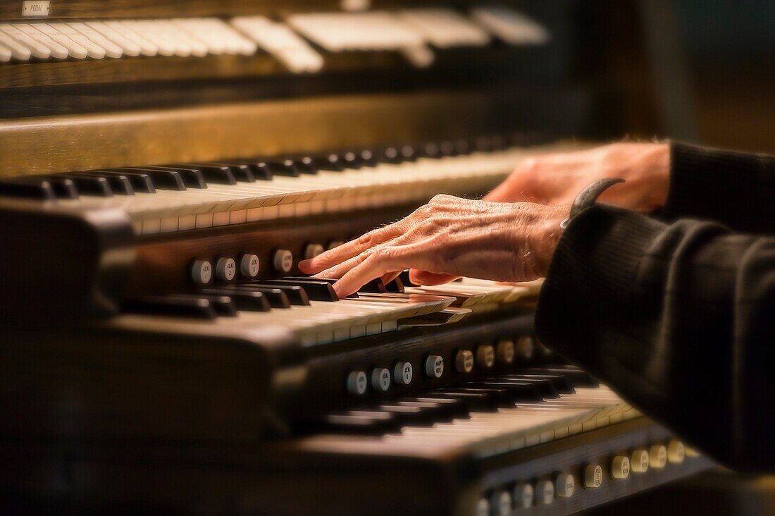 Hands playing a church organ