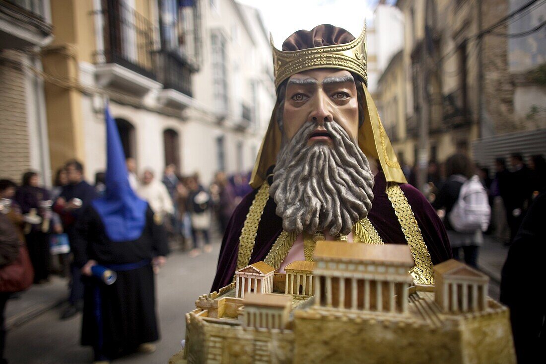 A masked man dressed as a biblical character holds a relic during an Easter Holy Week procession in Puente Genil, in the province of Cordoba, Andalusia, Spain.