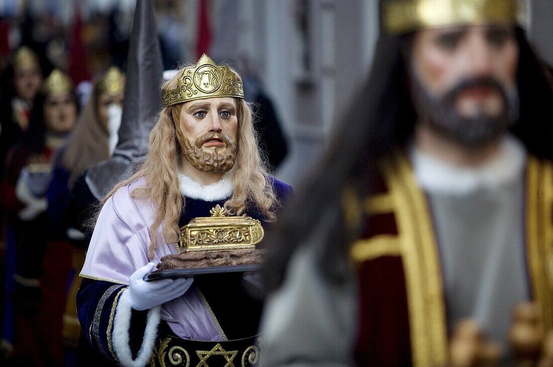 A masked man dressed as a biblical character holds a relic during an Easter Holy Week procession in Puente Genil, in the province of Cordoba, Andalusia, Spain.