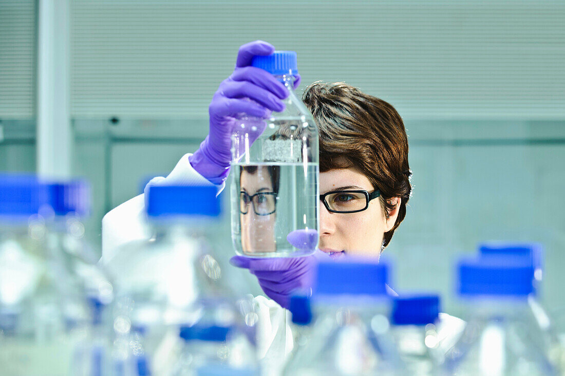Scientist examining jars in lab. University teaching lab
