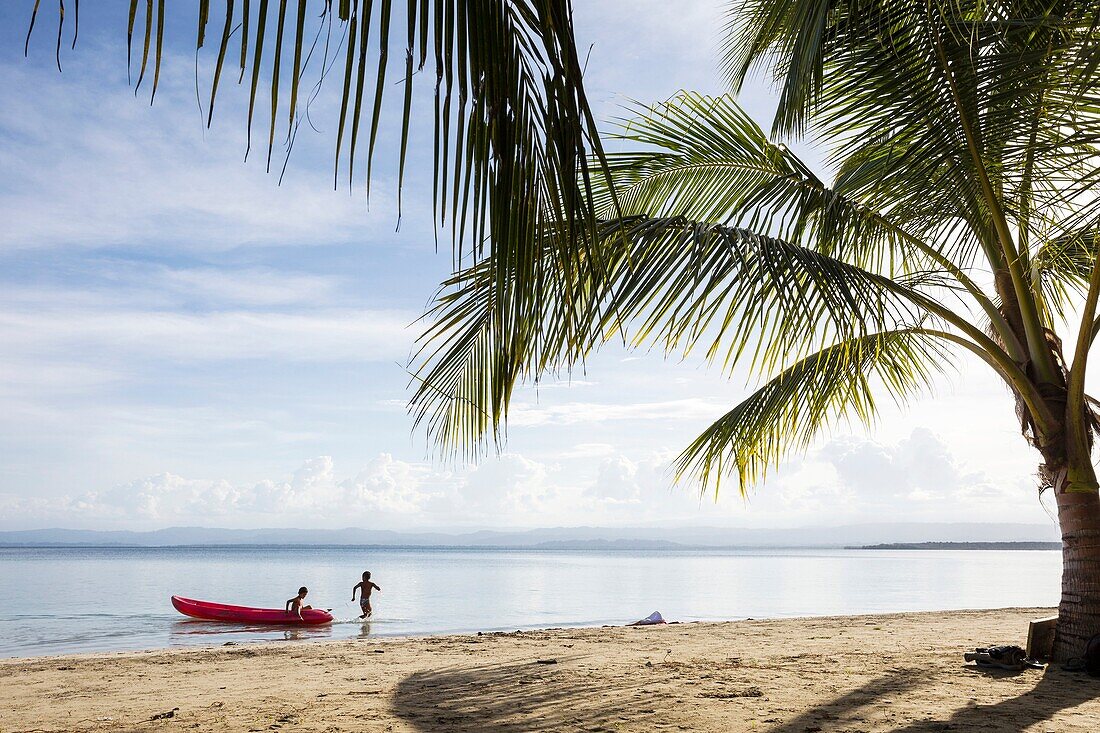 Two boys playing in the ocean at Starfish beach on Isla Colon Bocas del Toro, Panama