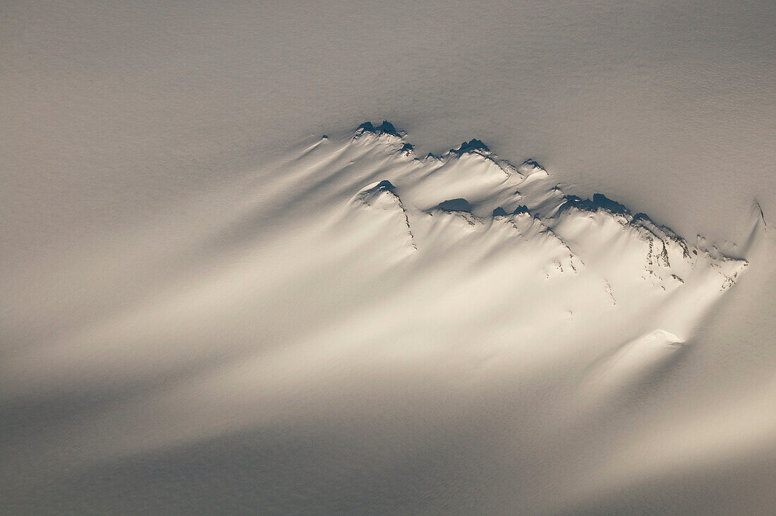 Aerial of a windswept nunatak on the Harding Ice Field in Kenai Fjords National Park, Southcentral Alaska, Winter