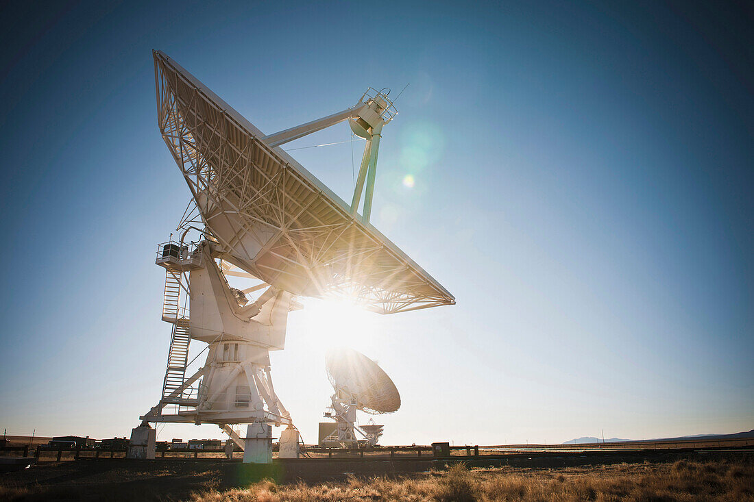 Radio telescopes in the landscape in New Mexico.  Antennae in rows.
