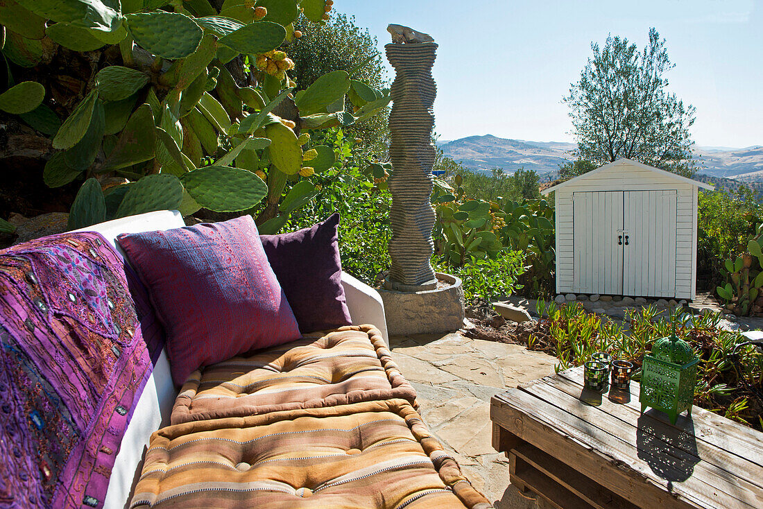A villa terrace, Bench furnished with pillows, overlooking the mountain landscape in Andalucia