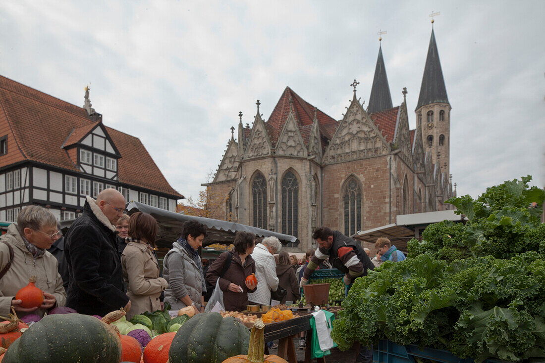 Medieval market square in the old town with Gewandhaus, Rueninger Customs House and St Martini church, market in the foreground selling vegetables, cabbage and pumpkins, Brunswick, Lower Saxony, Germany