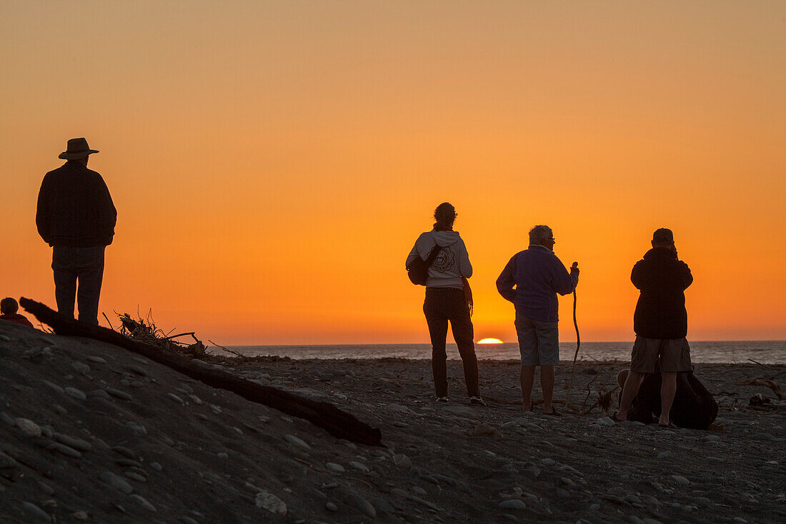 Menschen am Strand bei Sonnenuntergang, Silhouette, Südinsel, Neuseeland
