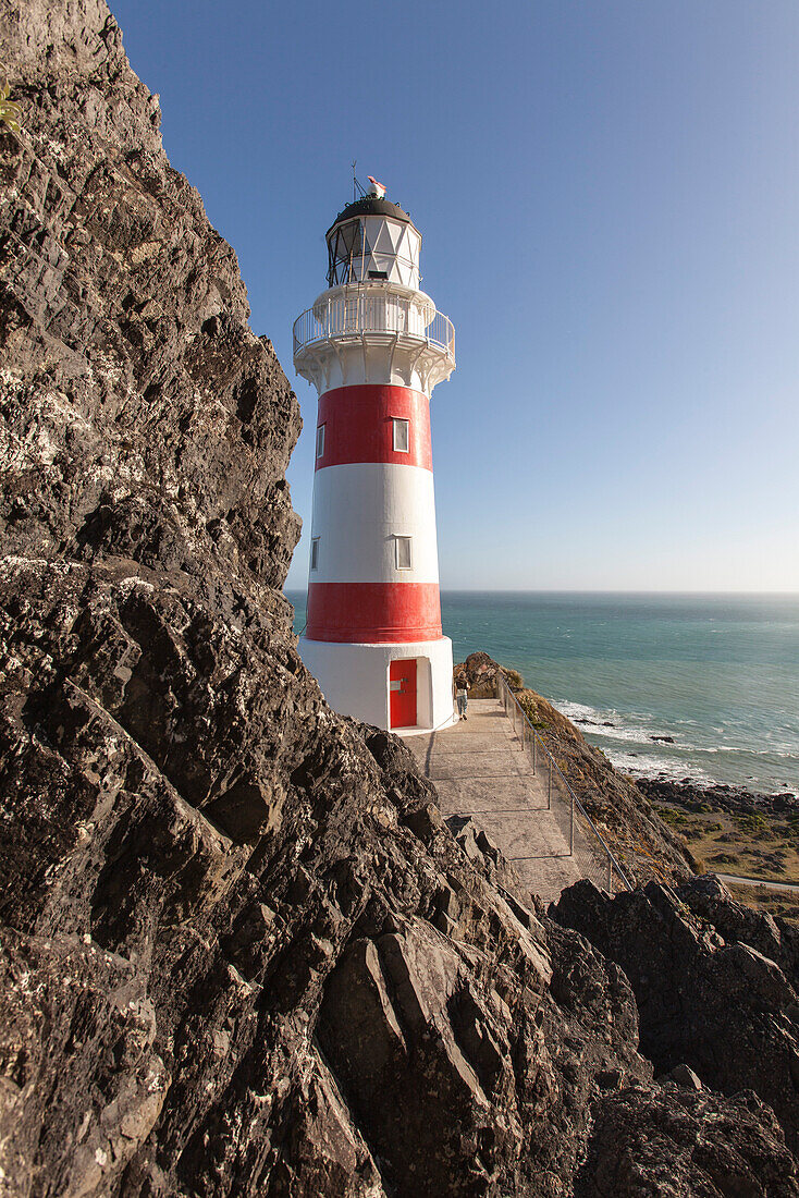 Cape Palliser Lighthouse, unterhalb Felswand, Cape Palliser, Nordinsel, Neuseeland