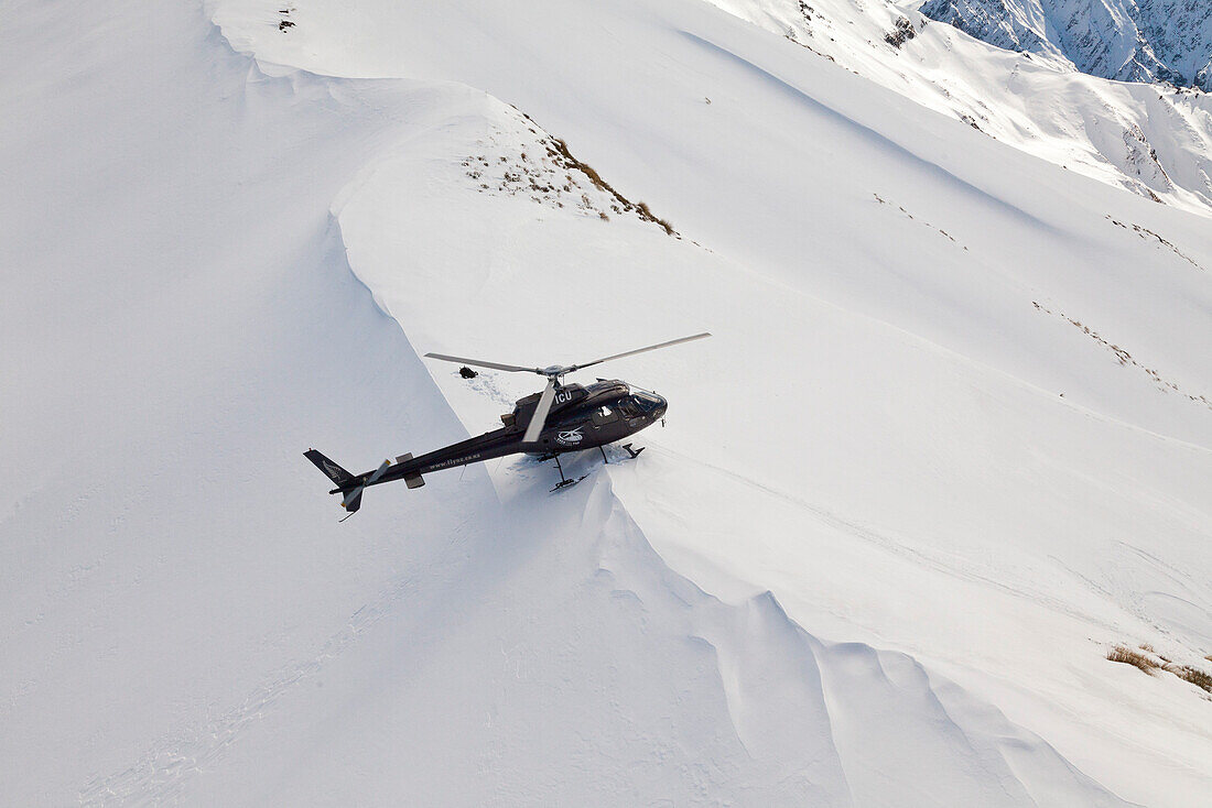 Helicopter landing with skiers and snowboarders in deep snow, Winter sport, Heliskiing, South Island, New Zealand