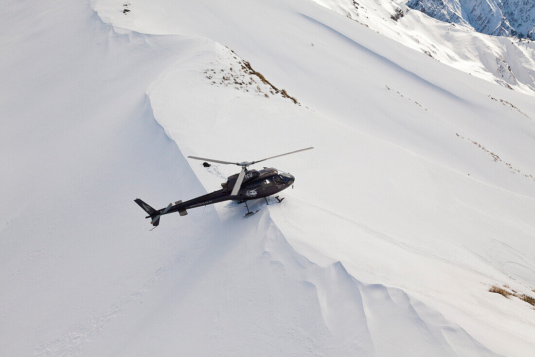 Heliskiing bei Queenstown,Hubschrauber landet Skifahrer,Snowboarder im Tiefschnee,Südinsel,Neuseeland