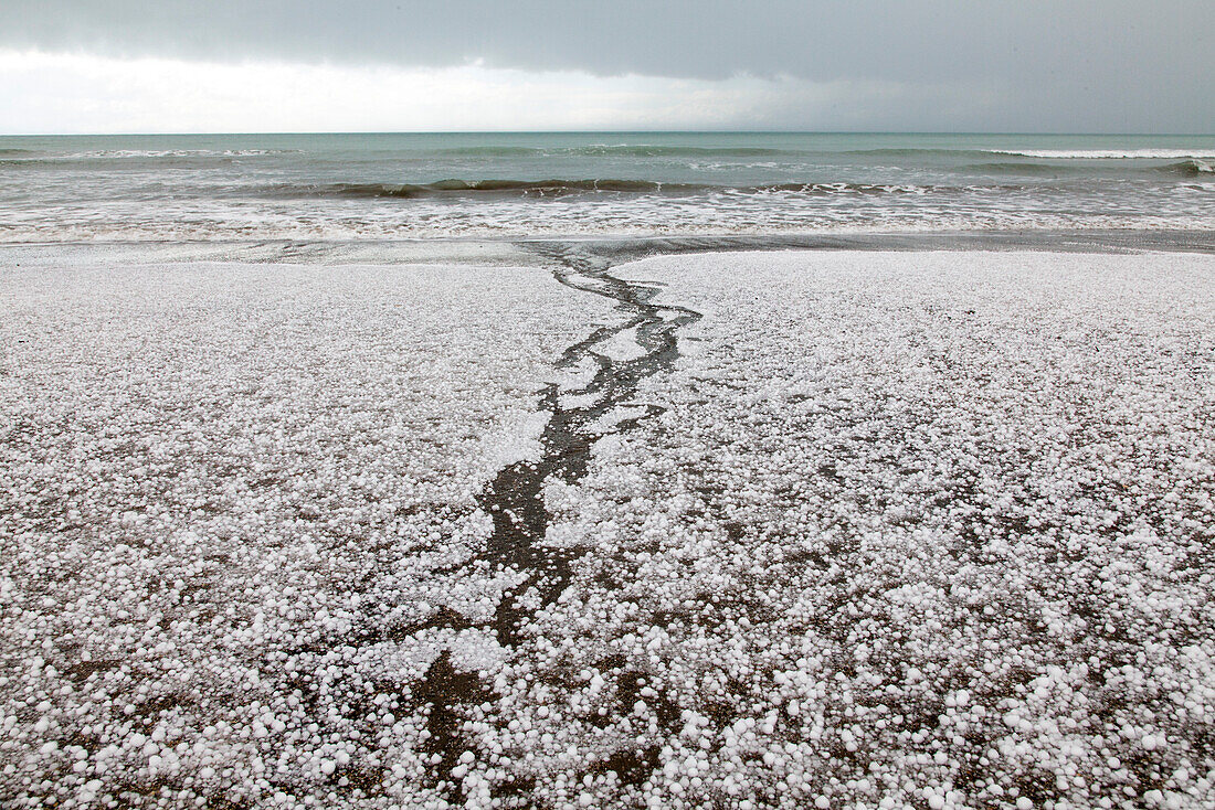 Hagel auf Sandstrand nach einem Sturm an der Ostküste, Marfells Beach, Südinsel, Neuseeland