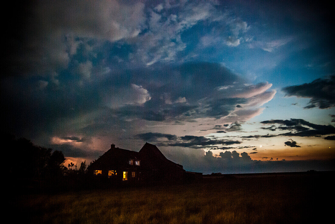 Dark Farm House Under Turbulent Sky During Electrical Storm