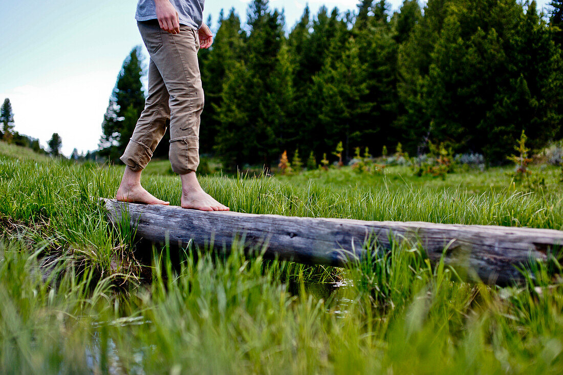 Young Man Crossing Log Barefoot