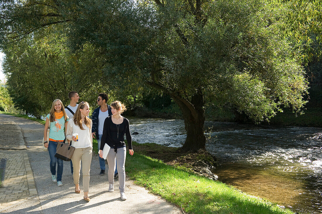 Young people walking along river Dreisam, Freiburg im Breisgau, Black Forest, Baden-Wurttemberg, Germany