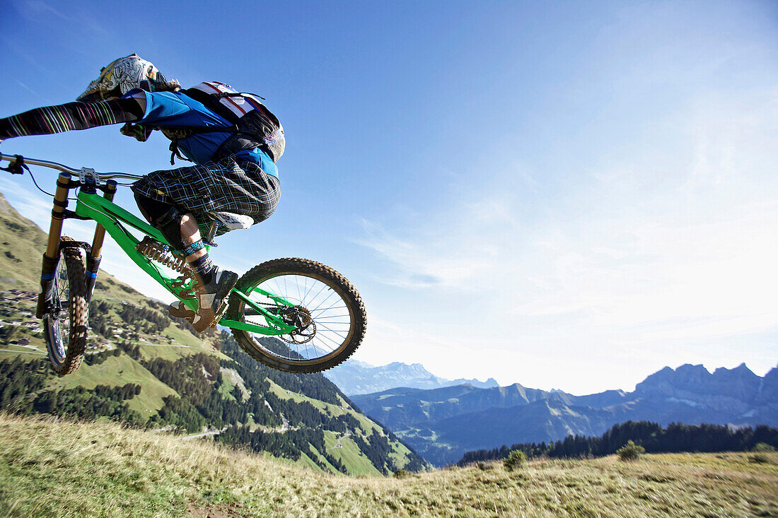Freeride mountain biker jumping, Chatel, Haute-Savoie, France