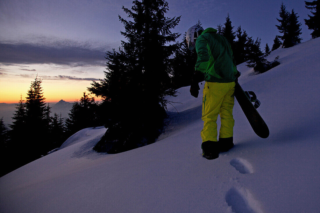 Snowboarder ascending through deep powder snow, Hahnenkamm, Tyrol, Austria