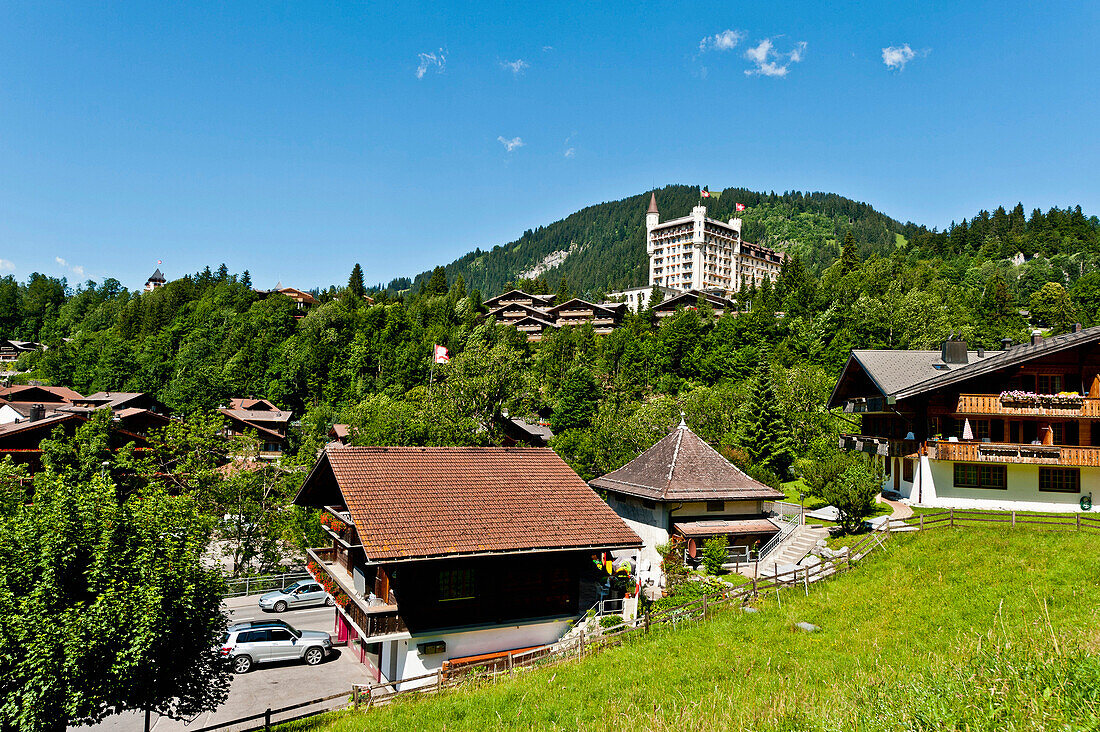 View to the hotel Palace and tipical swiss houses at Gstaad, bernese Oberland, Swiss, Europe