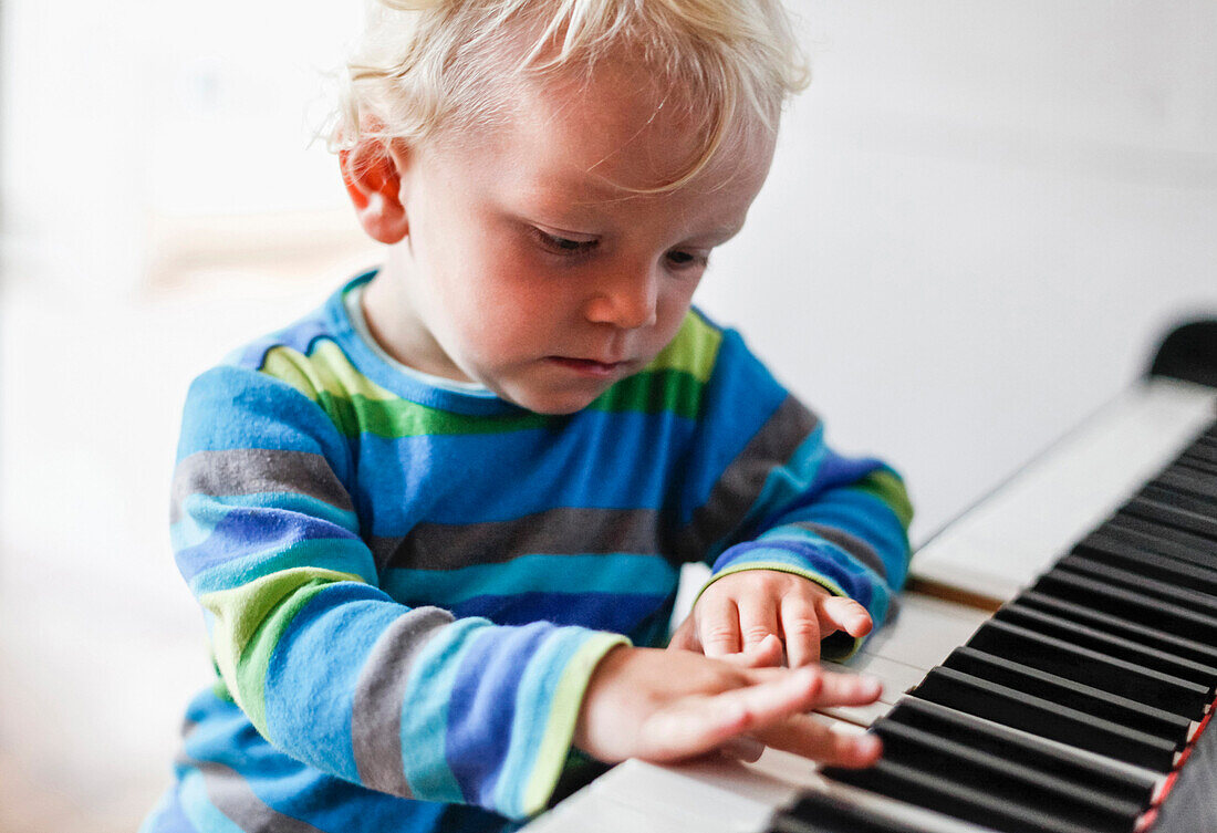 Junge (2 Jahre) spielt Klavier, Schwerin, Mecklenburg-Vorpommern, Deutschland