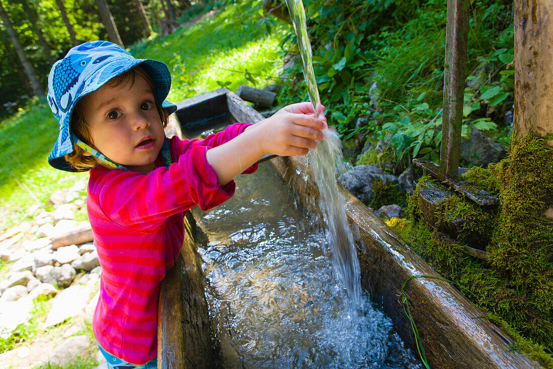 Mädchen wäscht sich die Hände an einem Brunnen, Plankensteinhütte, Plankenstein, Rottach-Egern, Bayern, Deutschland