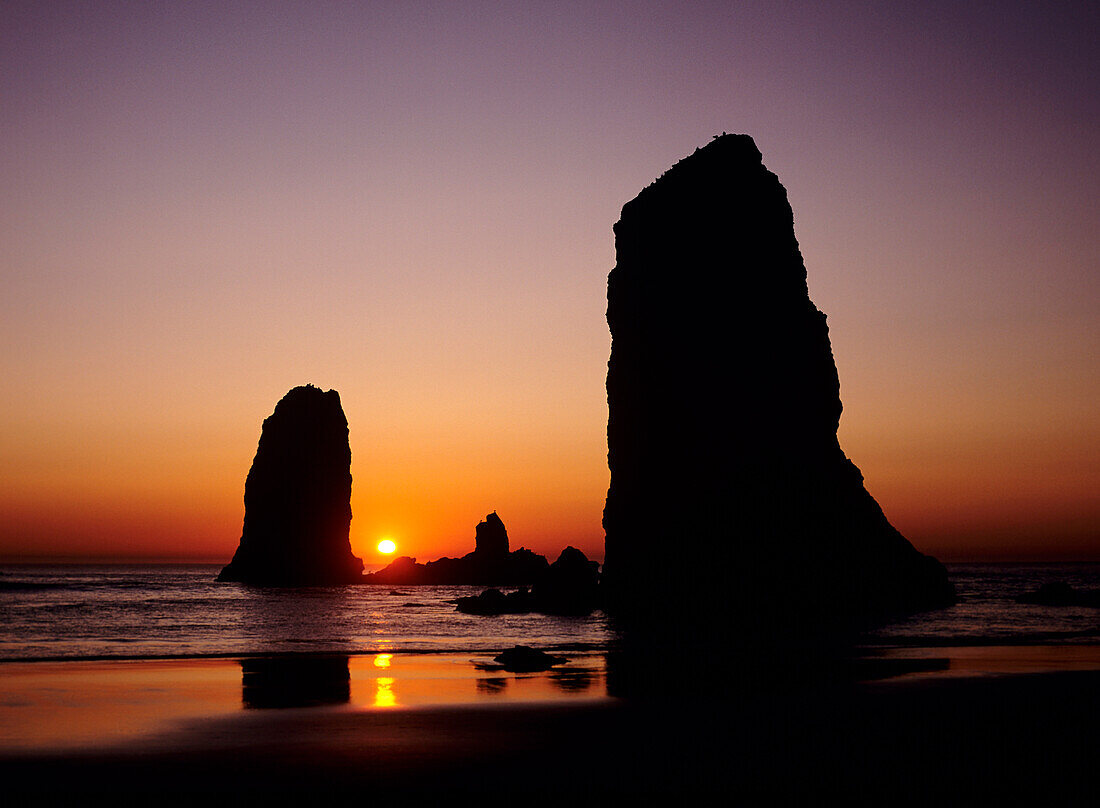 Oregon, Cannon Beach, Sea stacks near Haystack Rock at sunset.