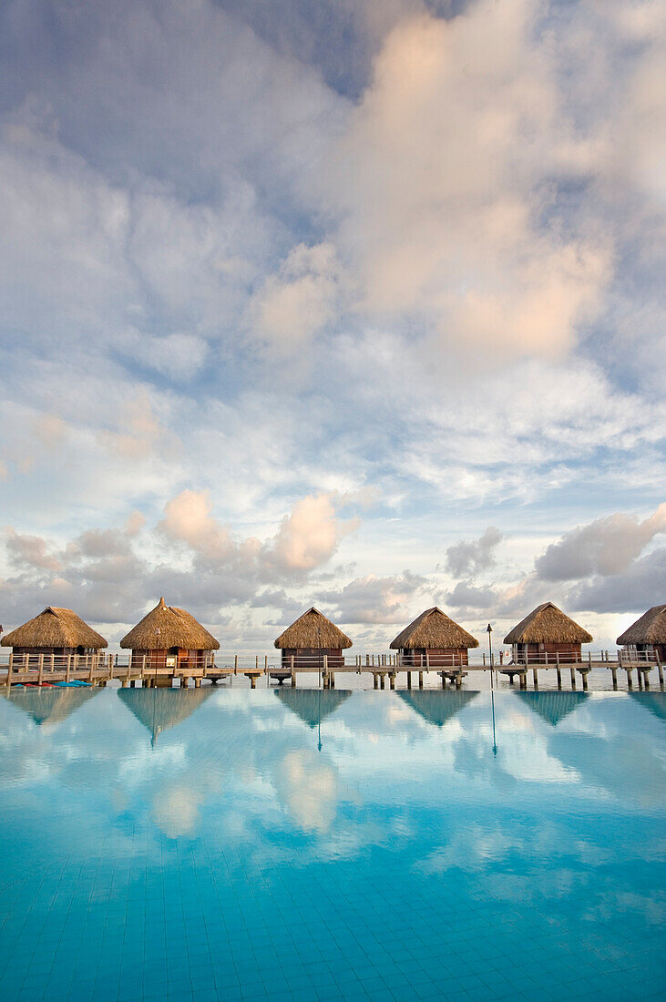 French Polynesia, Pearl Resort, Bungalows over beautiful turquoise ocean.