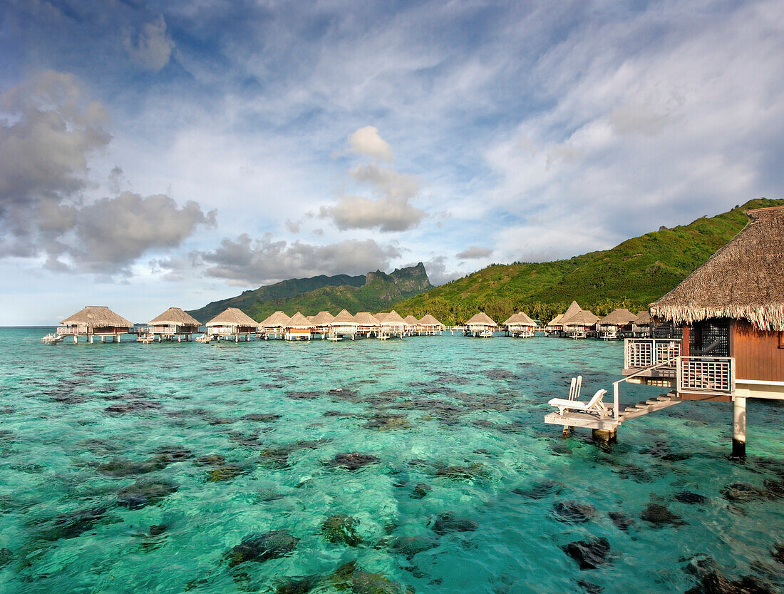 French Polynesia, Moorea Lagoon Resort, Bungalows over beautiful turquoise ocean.