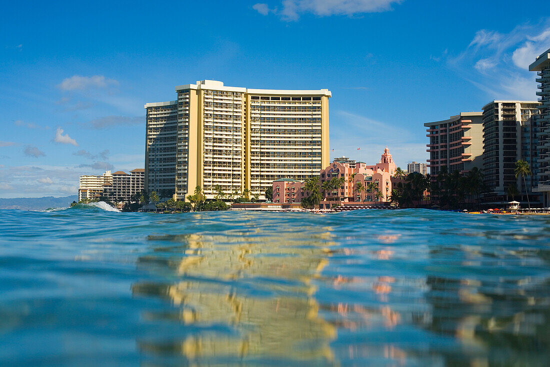 Hawaii, Oahu, Waikiki, Sheraton Waikiki and Royal Hawaiian Hotel seen from ocean with reflections.