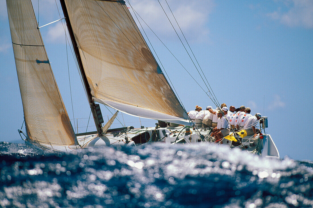 Hawaii, Kenwood Cup, Wave in foreground of crew sitting on yacht starboard side