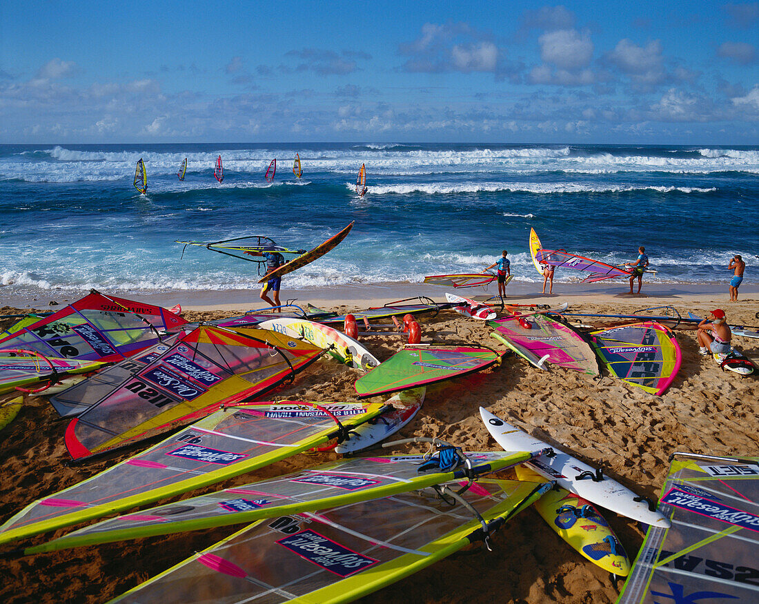 Hawaii, Maui, Hookipa Beach Park, world reknown for windsurfing, many colorful sails on beach athletes and spectators